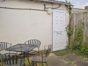 a patio with a table and chairs and a white door at Alnwick Loft in Alnwick