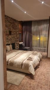 una camera con un grande letto e un muro di mattoni di Pirin Studios a Bansko