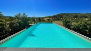 uma grande piscina com água azul em Exclusive pool - wondrous views - biological Gardens - pool house - 11 guests em Marzolini