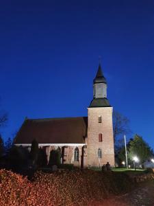 a large brick church with a tower at night at Haus Ole in Kröslin