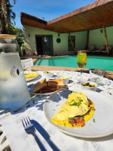 una mesa con un plato de comida y una copa de vino en Durbanville Pool House, en Durbanville
