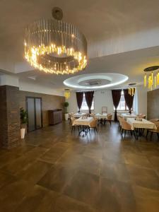 a dining room with tables and a chandelier at Sun Rise inn in Karagandy