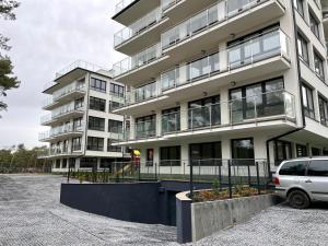 une camionnette blanche garée devant un immeuble dans l'établissement Hilltom Dunes, à Rowy