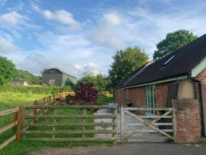 a wooden fence in front of a building with a barn at Cow Shed in Farden