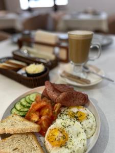 a plate of breakfast food with eggs and toast and a cup of coffee at Sun Rise inn in Karagandy