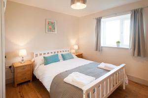 a bedroom with a white bed and a window at The Dairy Parlour in Cricklade