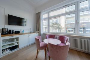 a kitchen with a table and chairs and a window at Logierhaus am Rathaus in Norderney