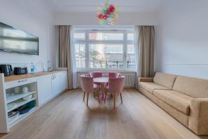 a living room with a couch and a table and chairs at Logierhaus am Rathaus in Norderney