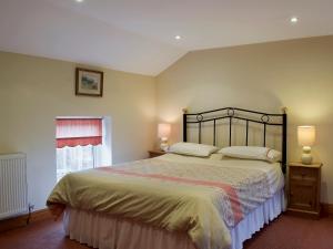una camera con un grande letto e una finestra di West Boundary Farm Cottage 1 a Pilling
