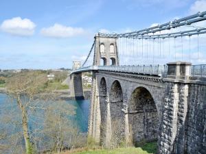 uma ponte sobre uma massa de água com em Bwthyn Bach em Caeathro