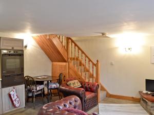 a living room with a staircase and a table at Robins Nest in Cromford