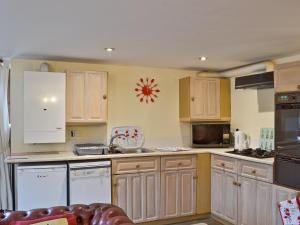 una cucina con elettrodomestici bianchi e armadietti in legno di Robins Nest a Cromford