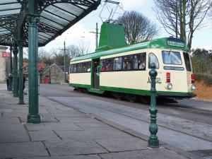 a green and white train pulling into a station at Robins Nest in Cromford