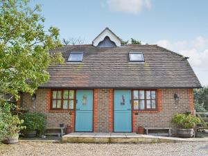 een klein rood bakstenen huis met blauwe deuren bij Rose Cottage - 30502 in West Firle