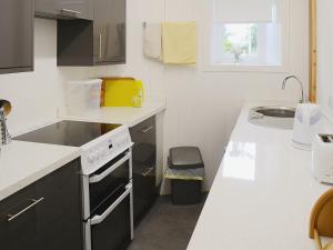 a kitchen with a sink and a stove top oven at Foundry Bank in Bonar Bridge