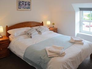 a bedroom with a large bed with towels on it at Foundry Bank in Bonar Bridge