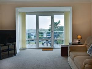 a living room with a couch and a sliding glass door at Bay View West Wing in Carlyon Bay