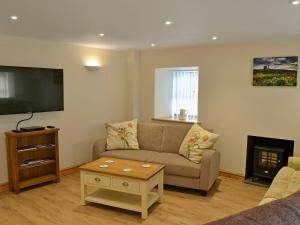 a living room with a couch and a tv at Llain Gam in Amlwch