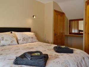 a bedroom with a bed with towels on it at Llain Gam in Amlwch