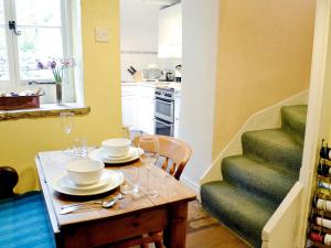 una cocina con una mesa con platos y copas de vino en Redmayne Cottage en Orton