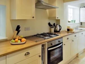 a kitchen with a bowl of fruit on a counter at Bank Cottage in Grindleford Bridge