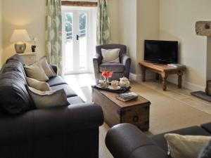 a living room with two couches and a tv at Bank Cottage in Grindleford Bridge