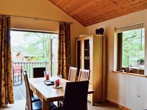 a dining room with a table and chairs and a balcony at Rowanburn Lodge in Ellonby