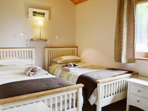 two twin beds in a room with a window at Rowanburn Lodge in Ellonby