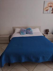 - un lit avec 2 oreillers bleus au-dessus dans l'établissement SWEET HOME GIULIA Locazione ad uso turistico, à Cimitile