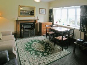 a living room with a table and a fireplace at Crook Farm in Torver