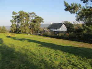 a large field with a house in the background at Crook Farm in Torver