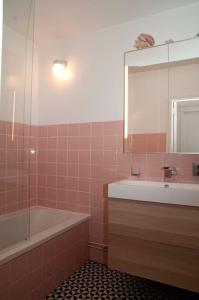 W łazience znajduje się wanna, umywalka i lustro. w obiekcie 2 bedroom appartement in Antwerp, with amazing view w Antwerpii