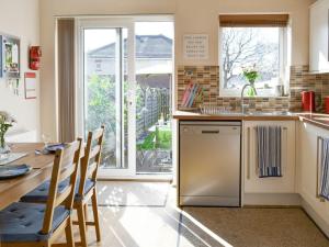 cocina con mesa, fregadero y lavavajillas en Signals Court, en Scarborough