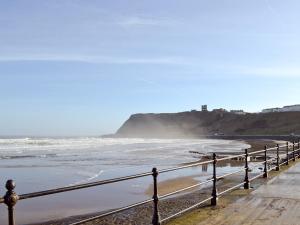 a beach with a fence and the ocean at Signals Court in Scarborough