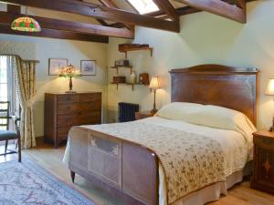 een slaapkamer met een groot bed met een houten hoofdeinde bij Dove Cote House in Westleigh