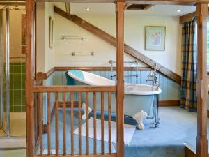 een badkamer met een bad en een wastafel bij Dove Cote House in Westleigh