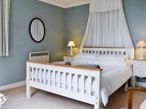 een slaapkamer met een witte wieg in een kamer bij The Garden Cottage in Wrafton
