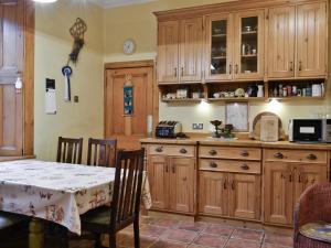 Bentpath的住宿－Ewes Schoolhouse，厨房配有木制橱柜和餐桌