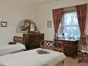 a bedroom with two beds and a dresser and a window at Ewes Schoolhouse in Bentpath