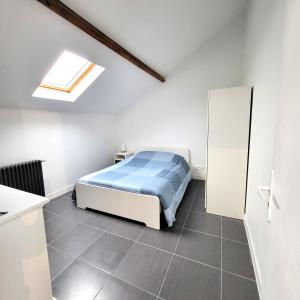 a white bedroom with a bed and a skylight at Residence du Parc des Grottes - N 3 in Juvisy-sur-Orge