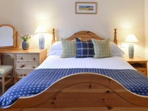 a bedroom with a large bed with blue and white pillows at Cluny in Aberfeldy