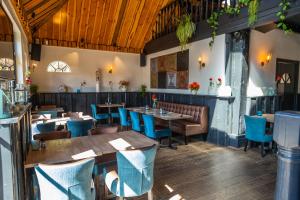 a restaurant with wooden tables and blue chairs at Comfort Rooms by EuroParcs Buitenhuizen in Velsen-Zuid