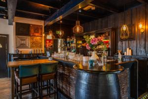 a bar with a woman standing behind a counter at Comfort Rooms by EuroParcs Buitenhuizen in Velsen-Zuid