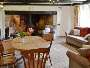 a living room with a table and a fireplace at Churchill Cottage in Holwell