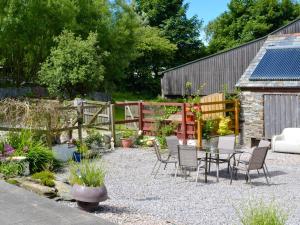 a patio with chairs and a table in a garden at The Granary - Hkkw in Lynton