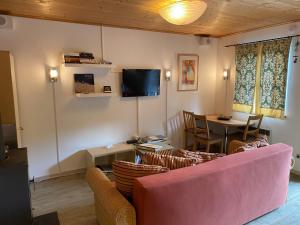 Una sala de estar con un sofá rosa y una mesa. en Turracher Berghütte, en Turracher Höhe