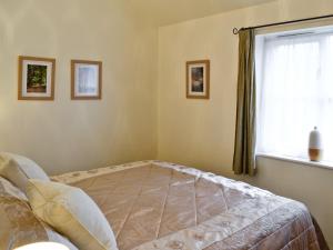 um quarto com uma cama e uma janela em Rose Cottage - W41462 em Sturminster Newton