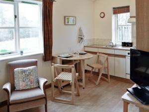 uma cozinha com mesa e cadeiras e uma cozinha com lavatório em Rose Cottage - W41462 em Sturminster Newton