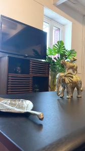 two elephant figurines sitting on a table in front of a tv at Le Troglo'Gîte, 500m à pied du Zoo de Beauval in Seigy