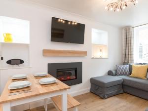 a living room with a table and a fireplace at One Beckside Cottage in Staithes